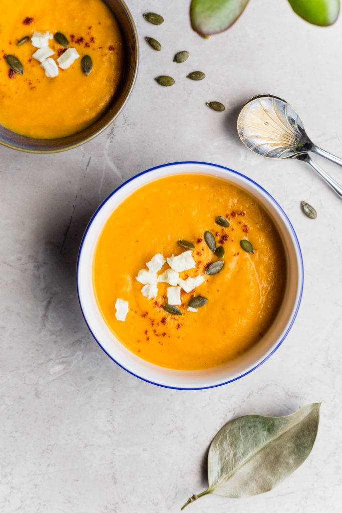 Image: Pumpkin Soup in a white porcelain bowl, sprinkled with toasted pepitas and flaky salt